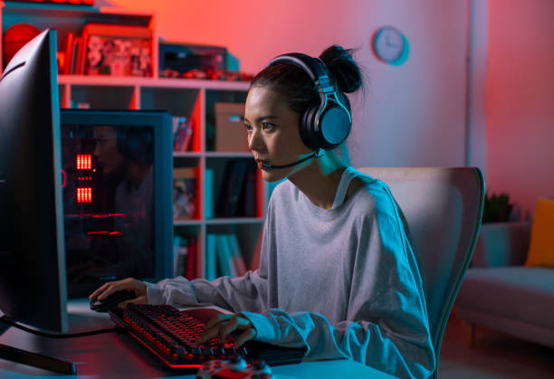 istock Young Asian woman concentrating on playing a video game 1563338419
