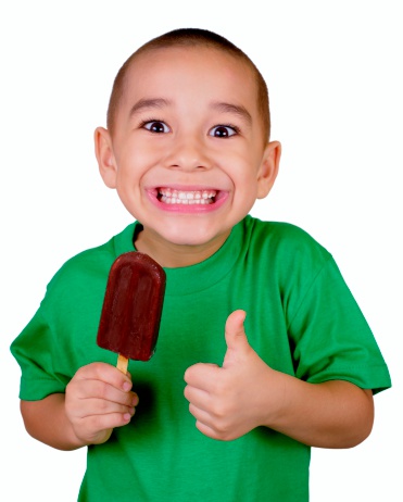 six year old boy ready to eat a chocolate ice cream bar, giving thumbs up sign, isolated on white background