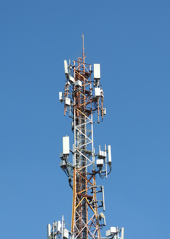 Telecommunication tower antenna at blue sky background