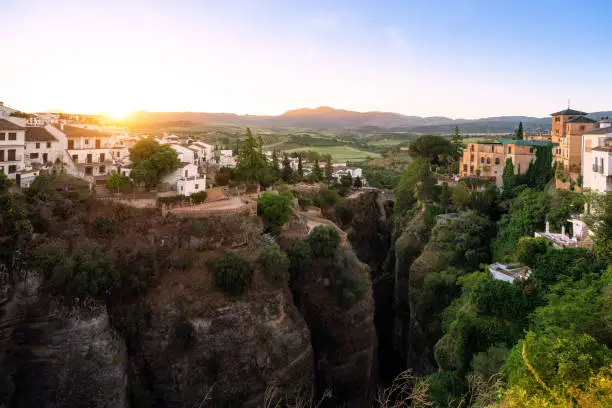 Photo of El Tajo Canyon at sunrise with Cuenca Gardens, Casa del Rey Moro and Puente Viejo Bridge - Ronda, Andalusia, Spain