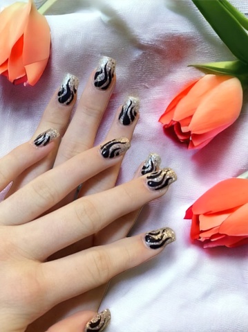 Beautiful female hand with red manicure nails, hearts and Valentine's day design