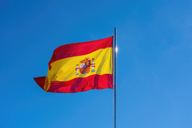 istock Flag of Spain on a blue sky 1563401865