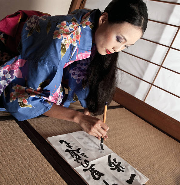 istock Beautiful Japanese geisha writing a calligraphic type 156343579