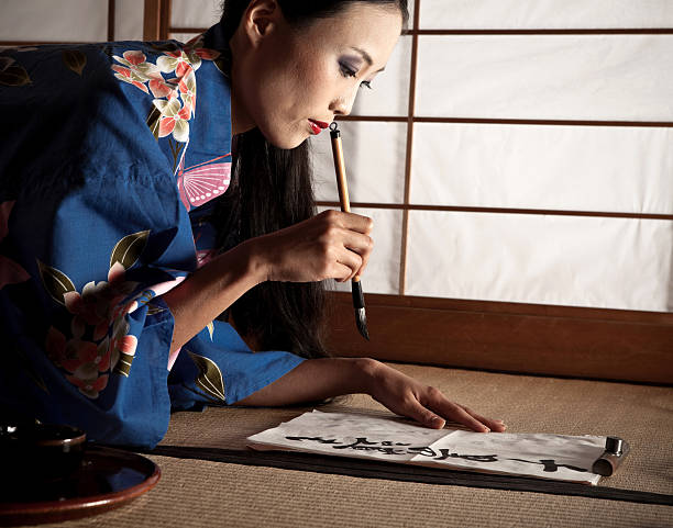 istock Beautiful Japanese geisha writing a calligraphic type 156343580
