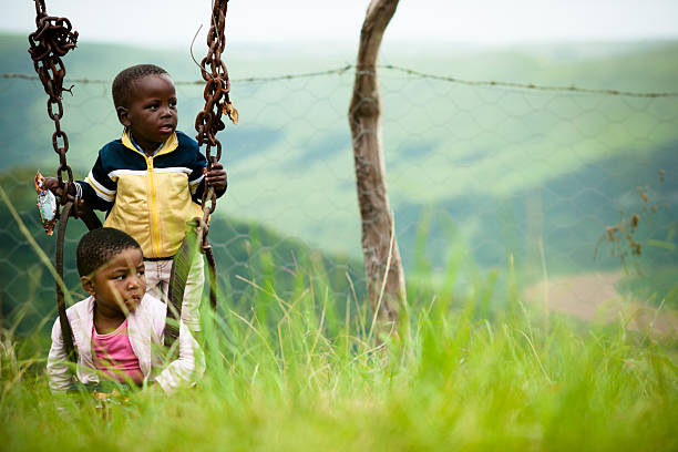 маленький народа коса девочка и мальчик сидит на качели - africa south africa child african culture стоковые фото и изображения