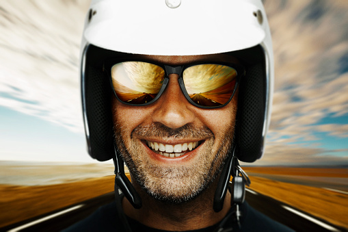 Happy biker on open road. Composite Image, shallow depth of field and grain added