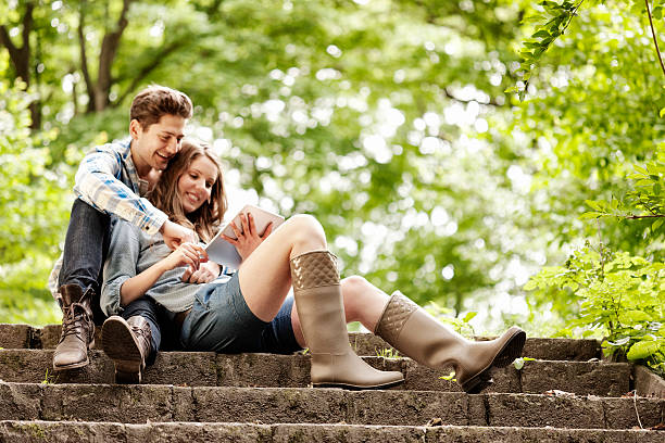 Young couple sharing a tablet computer outdoors