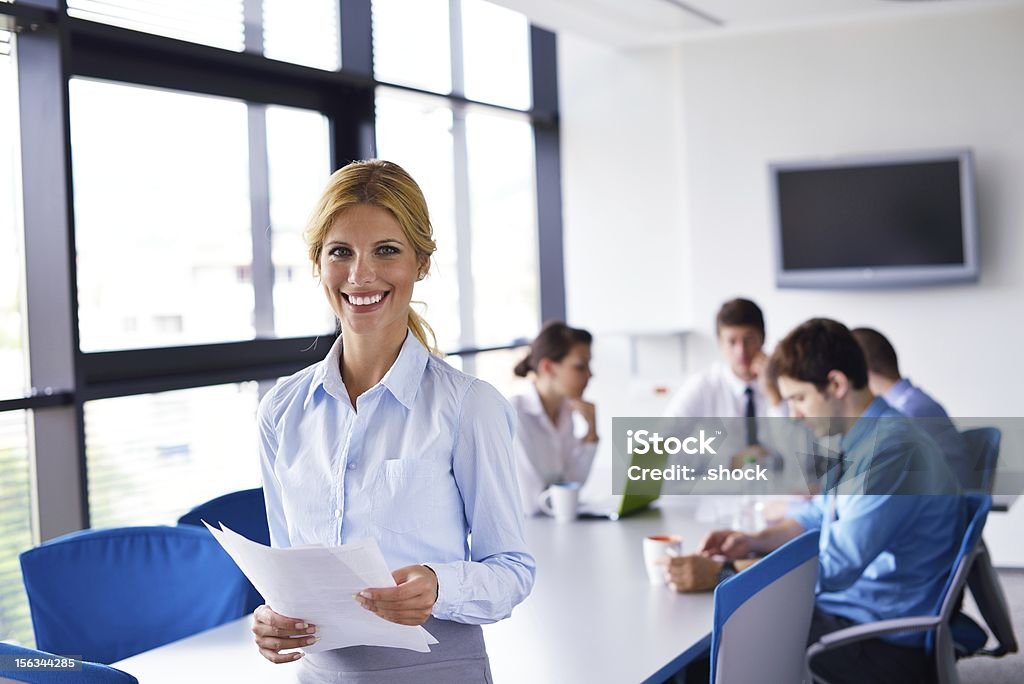 Деловая женщина с ее сотрудников в фоновом режиме в офисе - Стоковые фото Бизнес роялти-фри
