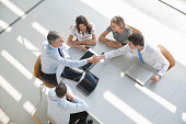 overhead view of a business group in a meeting shaking hands