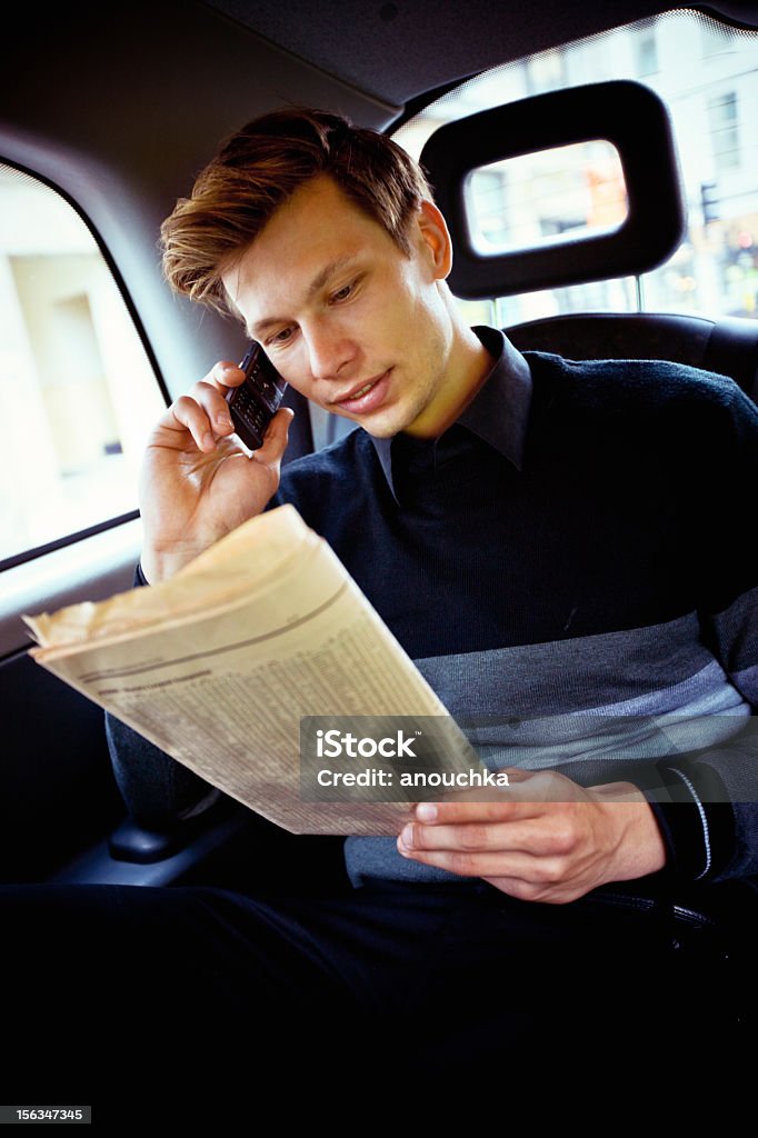 Young Businessman with newspaper in London Cab London - England Stock Photo