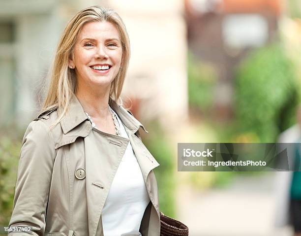 Una Sonriente Mujer Madura En La Calle Con Una Bolsa Foto de stock y más banco de imágenes de Adulto