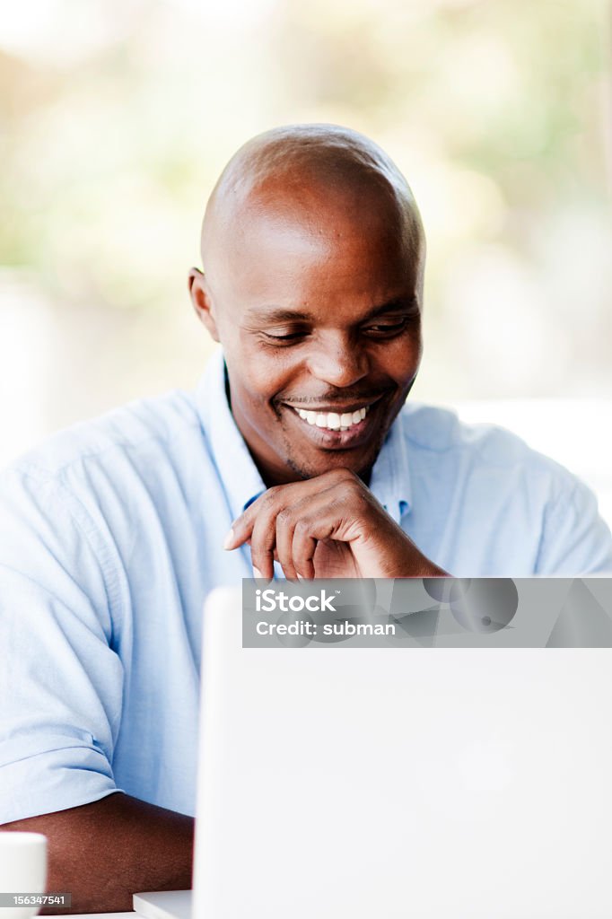 Uomo felice lavorando sul computer portatile - Foto stock royalty-free di Abbigliamento casual