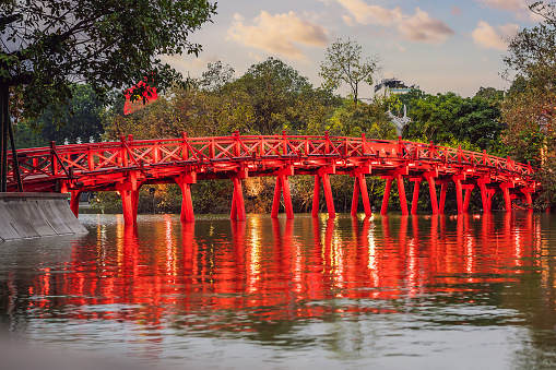 Hanoi Red Bridge at night. The wooden red-painted bridge over the Hoan Kiem Lake connects the shore and the Jade Island on which Ngoc Son Temple stands.