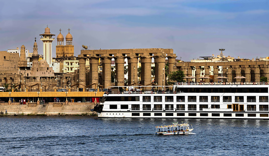 Luxor, Egypt, April 14, 2023: View of the right bank of Nile River in Luxorwith the ancient temple on a sunny spring day.