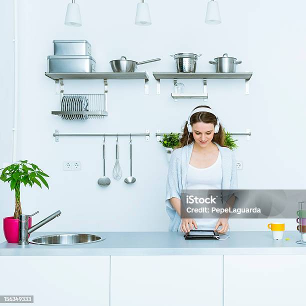 Foto de Mulher Tocando Músicas Em Um Tablet e mais fotos de stock de Interior de casa - Interior de casa, Mulheres, Vida doméstica