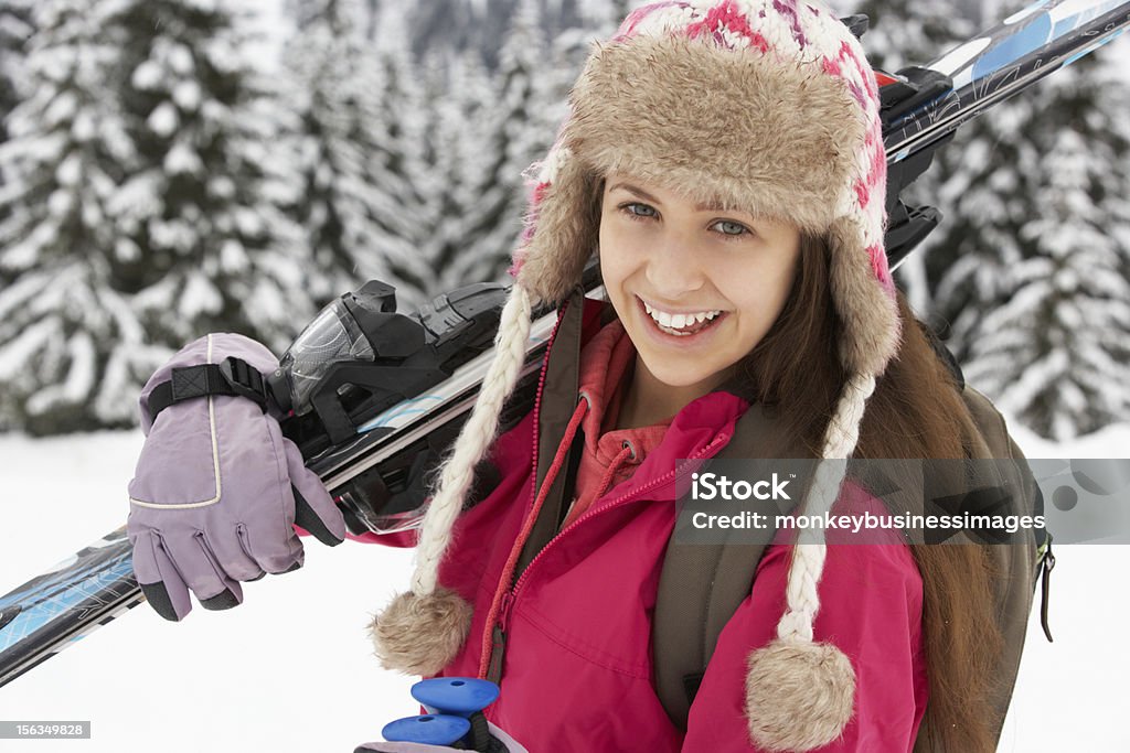Teenage Girl On Ski Holiday In Mountains Teenage Girl On Ski Holiday In Mountains Holding Skiis Smiling To Camera 14-15 Years Stock Photo