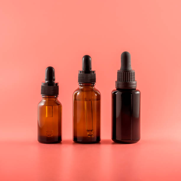 istock Vials of various heights with various essential oils on a pink background 1563506008