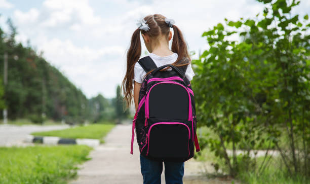 istock Back to school. cute child girl with backpack going to school 1563513416