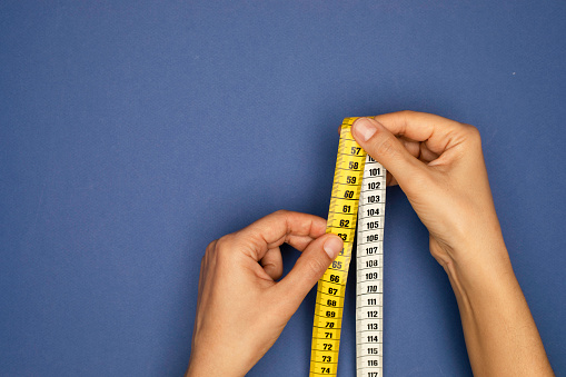 Woman holding tape measure.