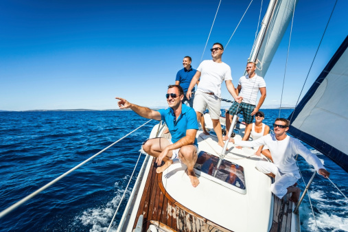 Caucasian man showing direction, laughing and  having fun on Sailboat.