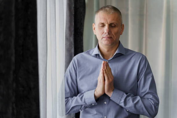 istock A man stands near the window doing relaxing breathing exercises. 1563548253