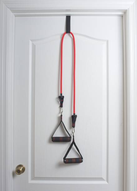 istock Home exercise bands hanging from a white door 1563584007