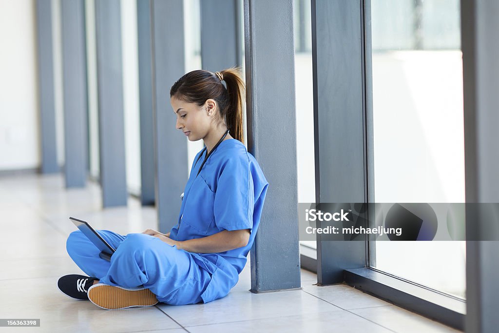간호사 앉아 사용하여 바닥용 및 노트북 컴퓨터 - 로열티 프리 의사 스톡 사진