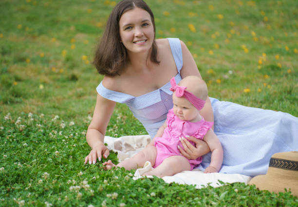 istock Young beautiful mother playing with her baby at park 1563639969