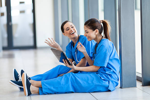 mujer joven de enfermería divirtiéndose con tableta - computer medical student hospital nurse fotografías e imágenes de stock