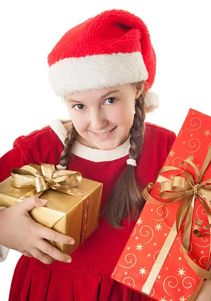Beautiful girl dressed in Christmas clothes and red santa hat with presents in her hands isolated on white background
