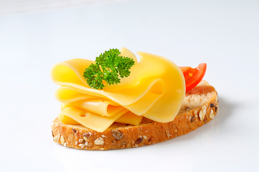 slice of wholegrain bread with fresh cheese, tomatoe and parsley