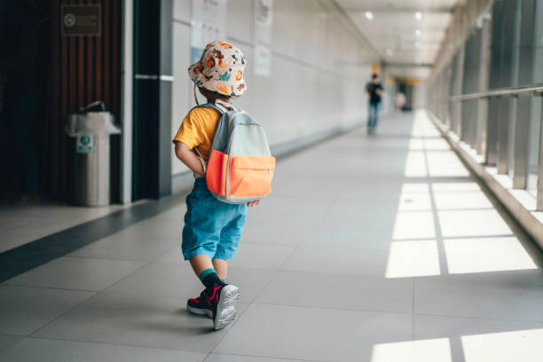 pre-school student  carrying rucksack while walking on the footbridge in city