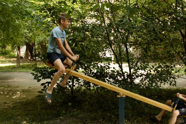 istock two boys ride on the playground of summer 1563683942