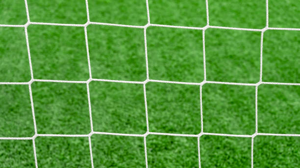 nahaufnahme eines fußballnetzes auf grünem grashintergrund auf fußballplatz. - tournament bracket fotos stock-fotos und bilder