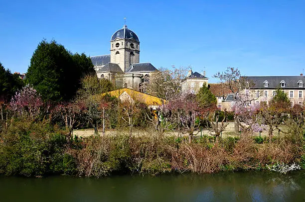 Sarthe river bank and bell tower of basilica Notre Dame at Alençon of the Lower Normandy region in France