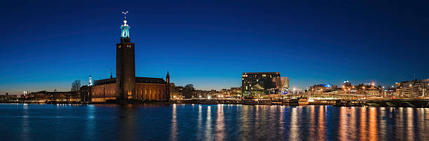 Stockholm City Hall waterfront illuminated Sweden Stars shining in the deep blue panormaic dusk skies over the iconic tower of Stockholm City Hall, Stadshuset, venue for the Nobel Prize banquet, the modern architecture of the downtown Norrmalm waterfront and Central station reflecting in the still waters of Riddarfjarden, Stockholm, Sweden. ProPhoto RGB profile for maximum color fidelity and gamut. kungsholmen town hall photos stock pictures, royalty-free photos & images