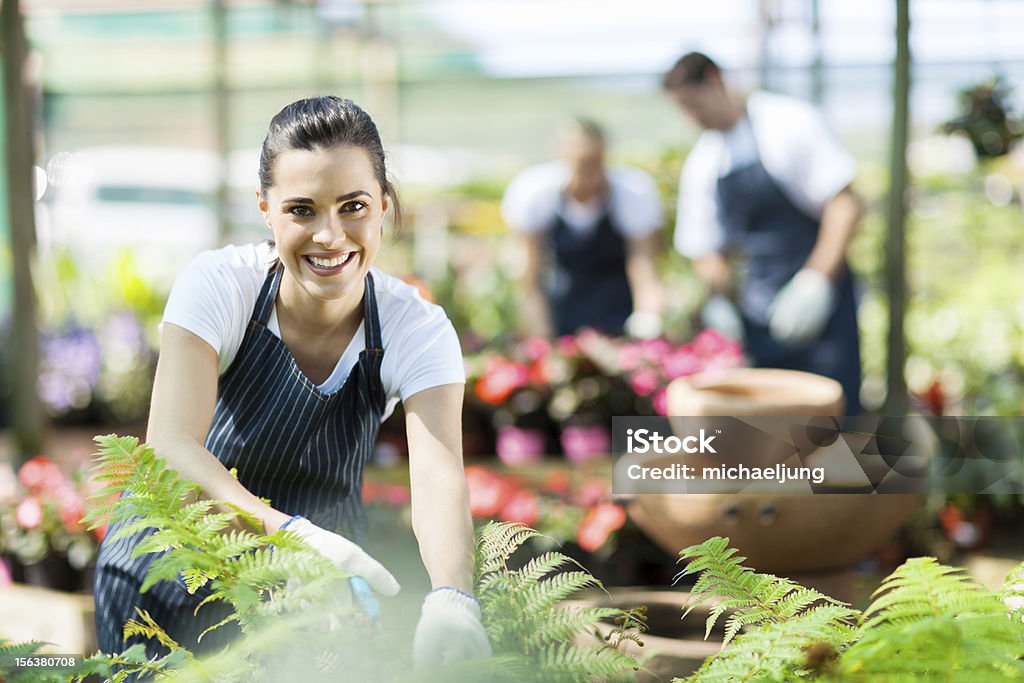 Счастливый Женский питомника работник обрезка растений - Стоковые фото Green Thumb - английское выражение роялти-фри