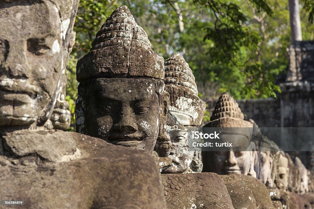 Giant guardie di Angkor Thom fronte alla porta d'imbarco in Cambogia - Foto stock royalty-free di Albero
