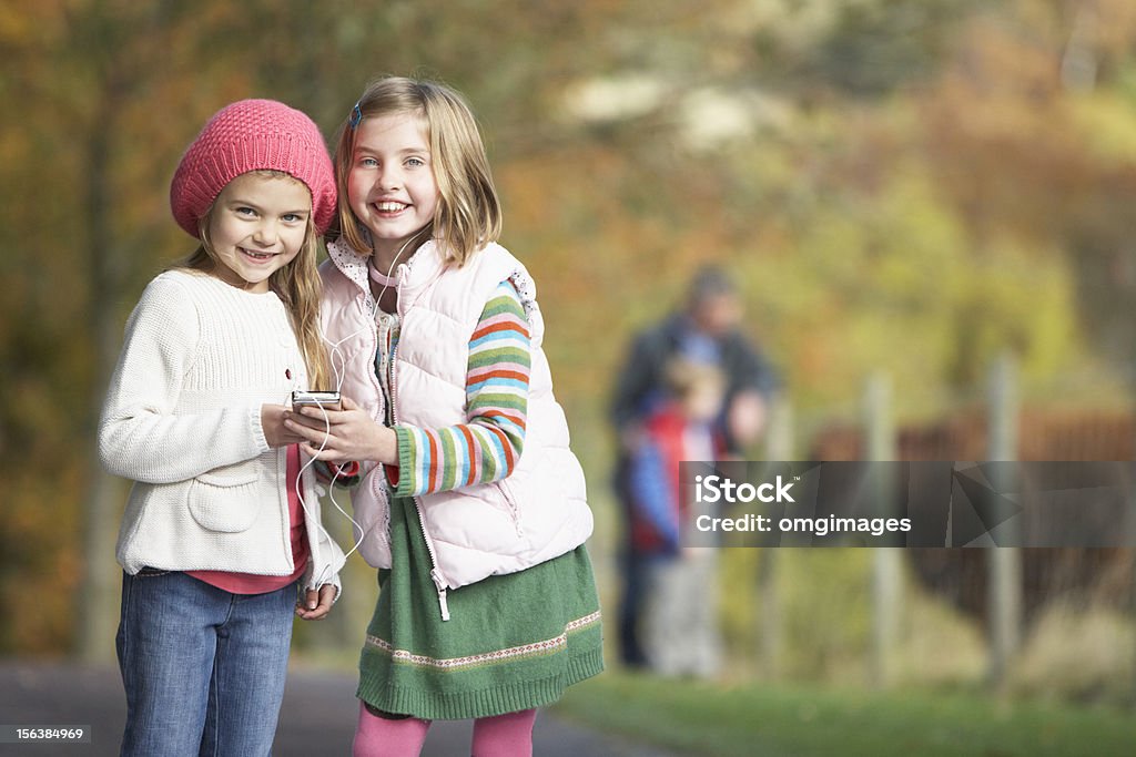 Deux jeune fille à l'écoute pour lecteur MP3 à l'extérieur - Photo de Enfant libre de droits