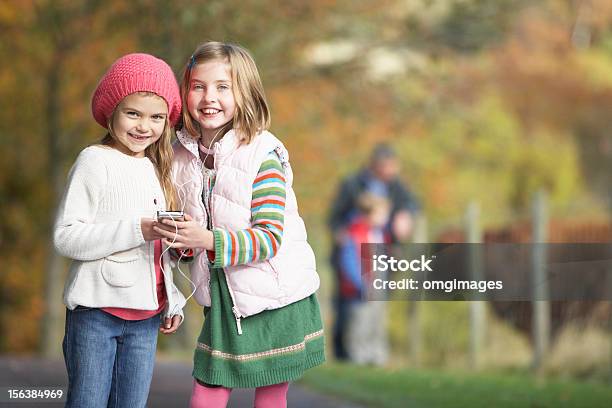 Dwa Młoda Dziewczyna Słuchając Odtwarzacza Mp3 Na Zewnątrz - zdjęcia stockowe i więcej obrazów Dziecko