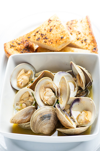Steamed clams and garlic oil toasts on white background