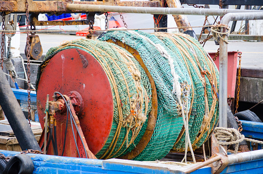 Fishing net roll on fisherman boat traps, and fishing lines to catch the fish, and then use complex machinery to hoist fish loads onto a boat.