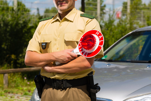Police - policeman or cop in uniform stop car in traffic control