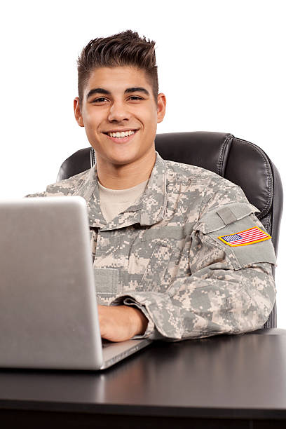 Smiling soldier works at his desk stock photo