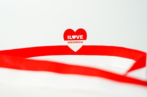 Bright red ribbon that's thin and curved into the shape of a heart. The ribbon curves around to create the heart and is not tied. One end of the ribbon curves up and then back down, and the other curves to form the shape of a point where they overlap at the bottom. Great use for love and romance concepts. Isolated on white. Clipping path is included.