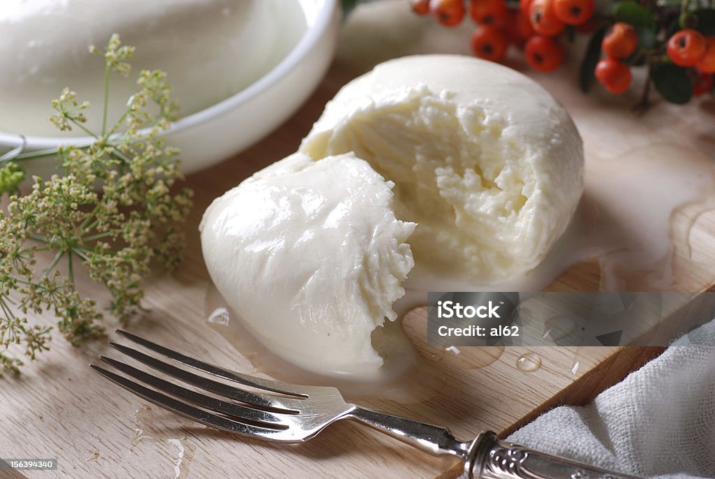 fresh mozzarella Sliced mozzarella with fork on wooden board Appetizer Stock Photo