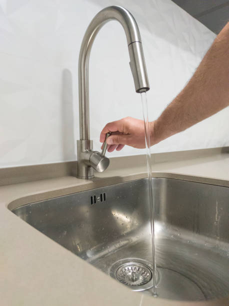 istock Male hand opening the kitchen sink tap 1563952096