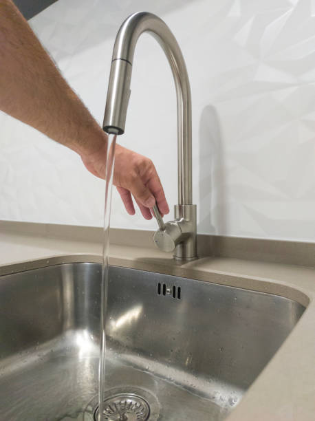 istock Male hand opening the kitchen sink tap 1563952373