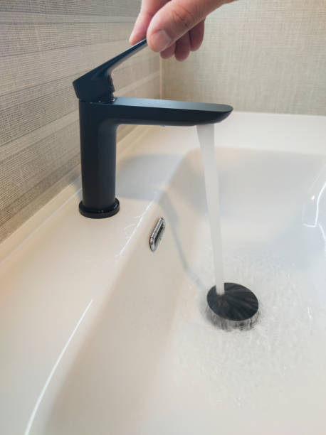 istock Male hand opening the sink tap 1563952610