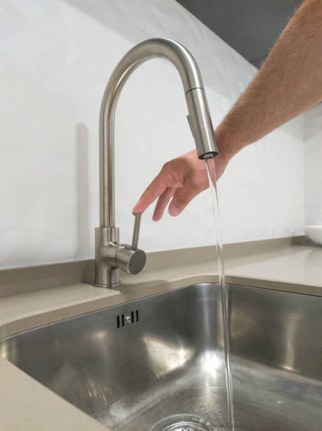 istock Male hand opening the kitchen sink tap 1563952619